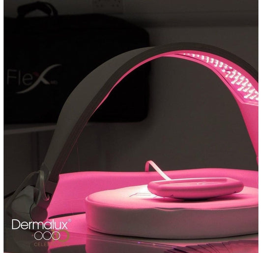 Pink LED light therapy device with 'Dermalux' branding on a dark background