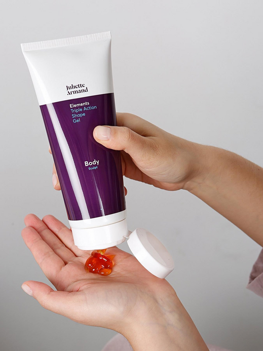 Hand holding a tube of Juliete Armand body gel with a small amount on the palm